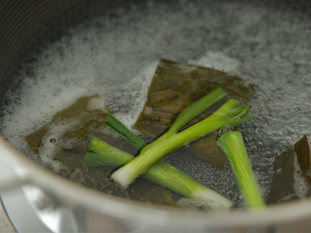 Scallions and dashima in pot of boiling water