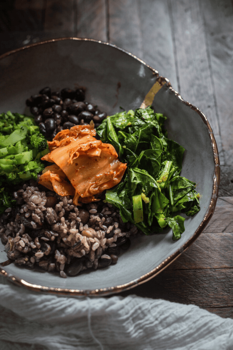 beans, rice, broccoli and collard greens together on white plate with gold trim