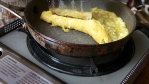 close up of rolling the tofu omelet