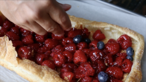 adding blueberries to berry galette