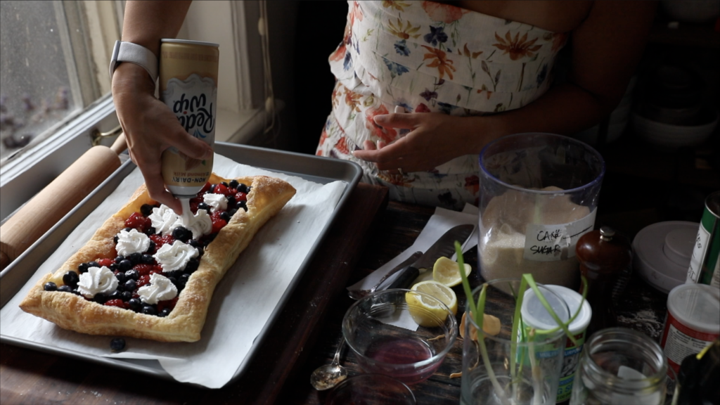 adding vegan whipped cream to berry galette