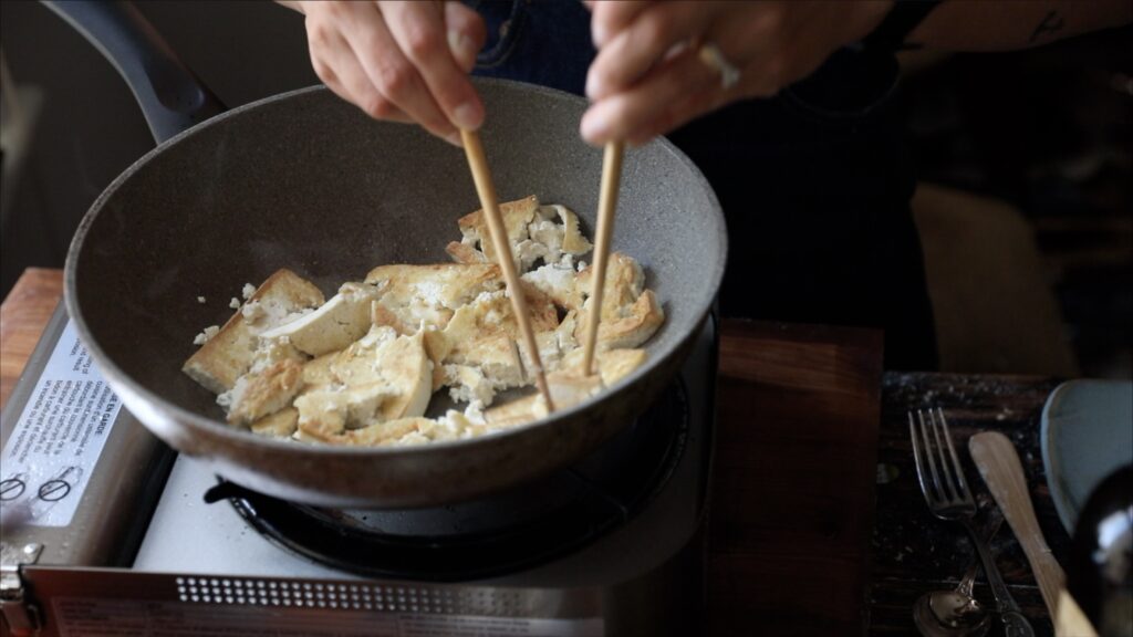 using chopsticks to create texture to tofu