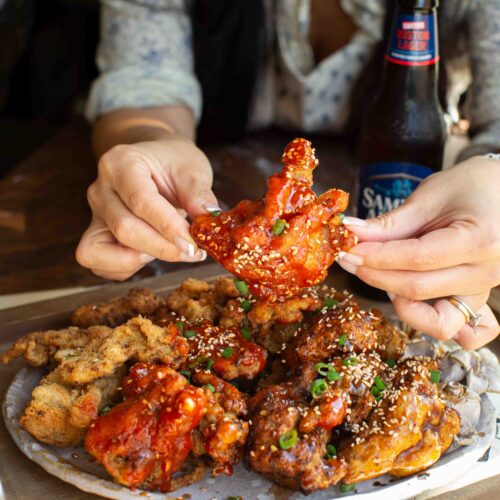 holding-vegan-fried-chicken-with-spicy-sauce