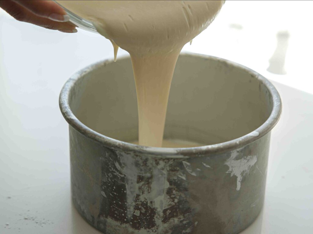 pouring cake batter into cake pan