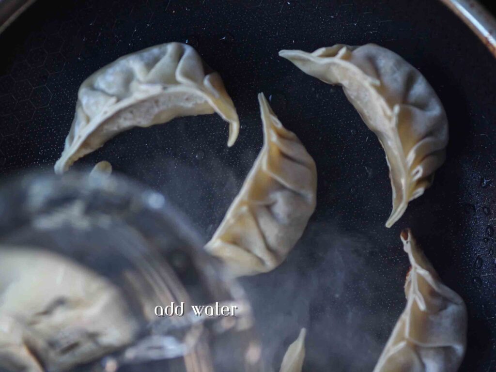adding-water-to-pan-of-potstickers