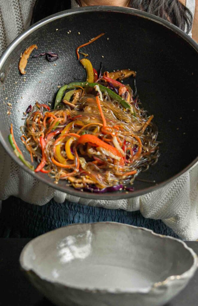 vegan japchae still in pan about to be poured into bowl