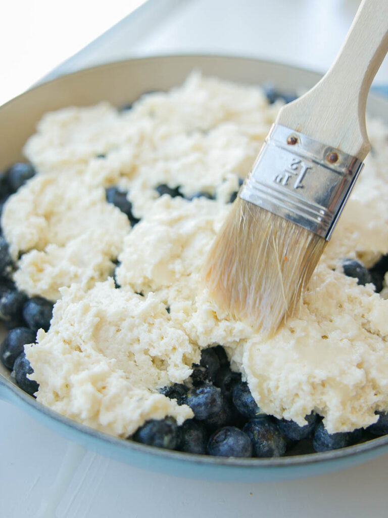 brushing-vegan-wash-on-top-of-vegan-blueberry-cobbler