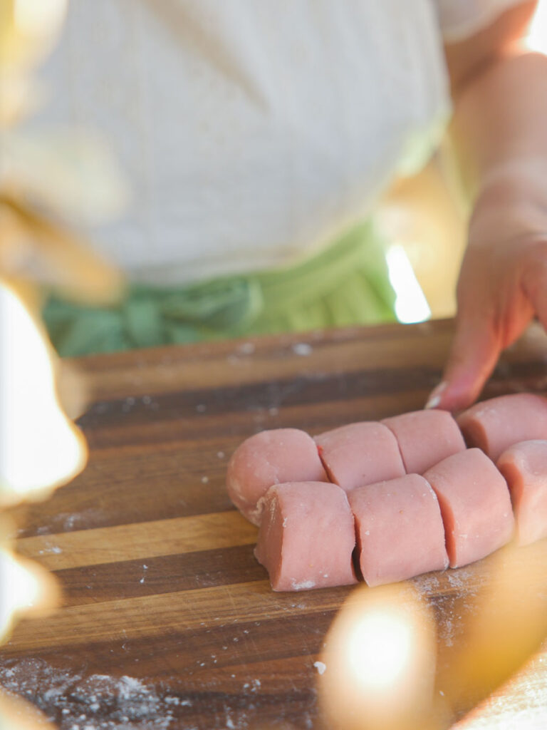 cutting pieces of pink mochi dough