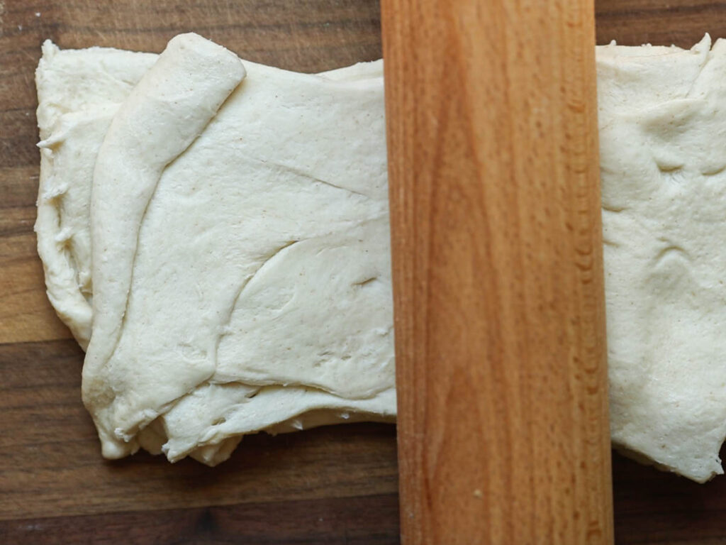 flattening-stack-of-crescent-roll-dough-with-rolling-pin