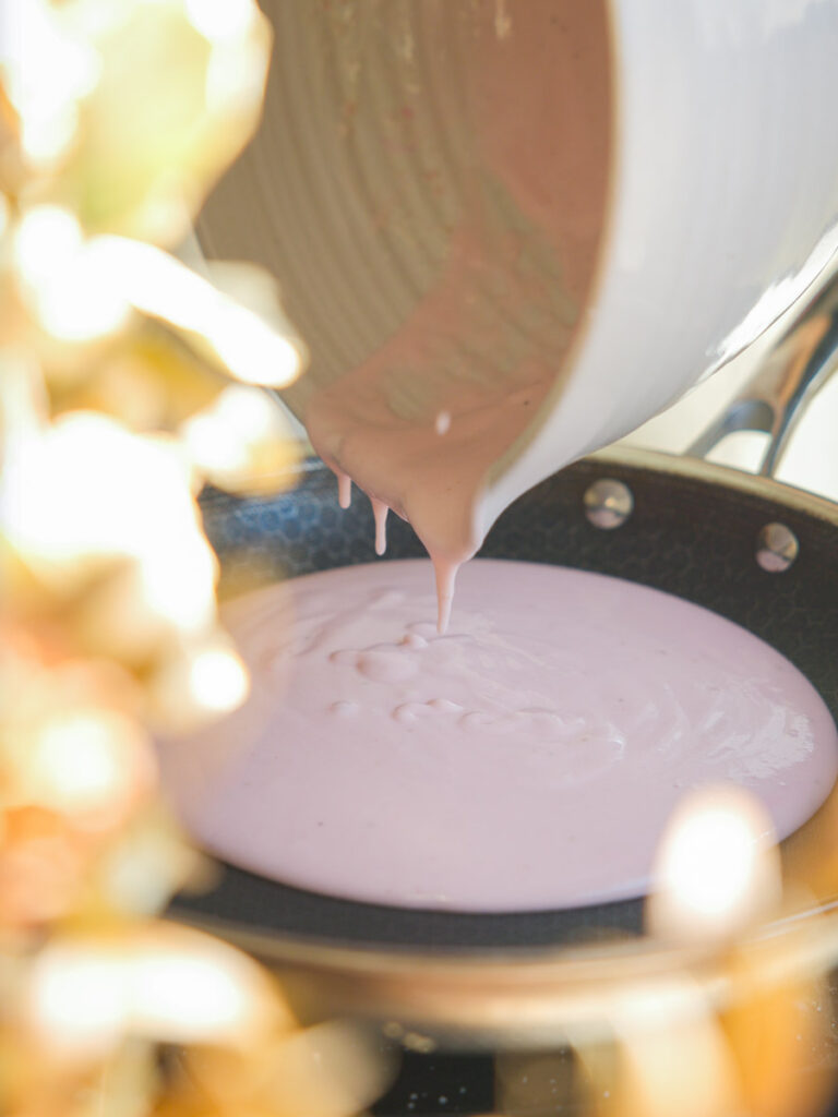 pouring pink mochi batter into pan