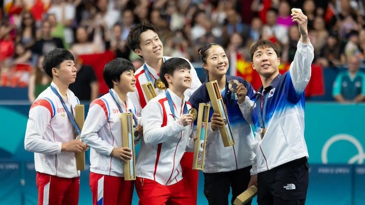 North Korean, South Korean, and Chinese Athletes celebrate together.