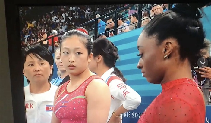 North Korean Olympian looking at Simone Biles