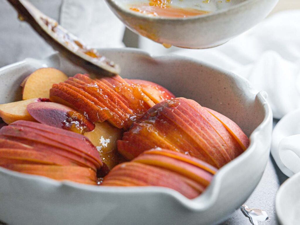 adding-peach-glaze-to-sliced-peaches