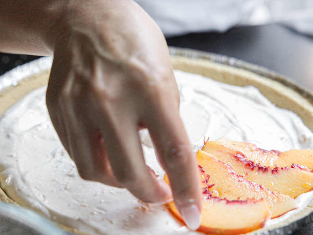 arranging-peach-slices-over-cream-cheese-filling