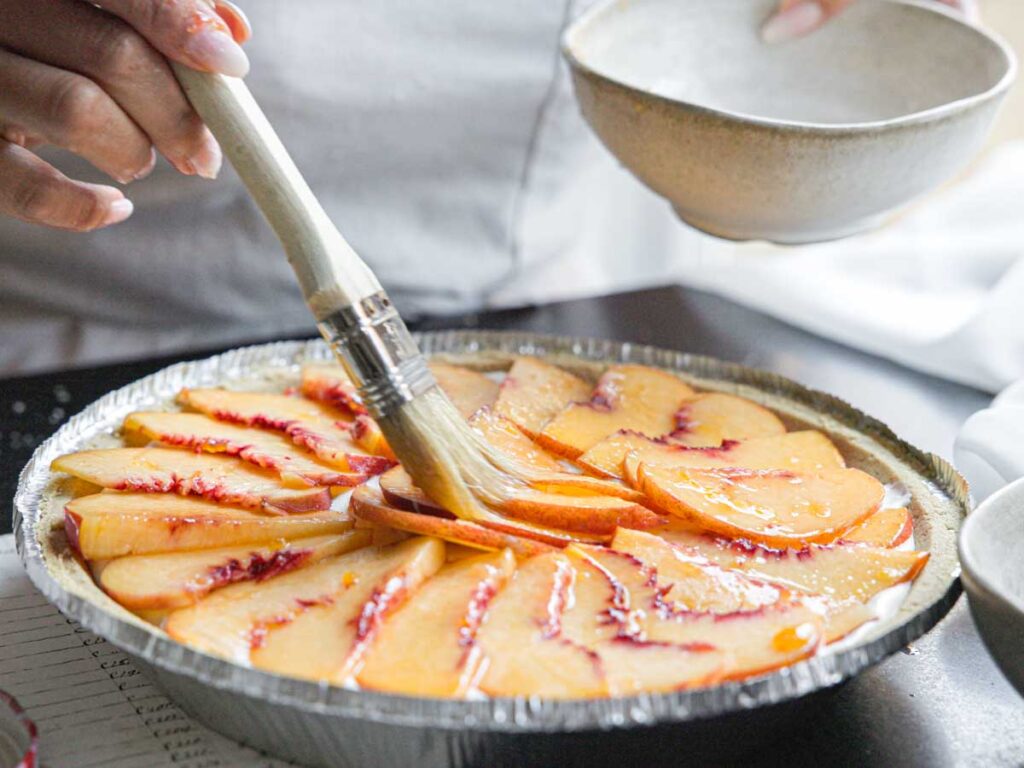 brushing-glaze-on-top-of-peaches