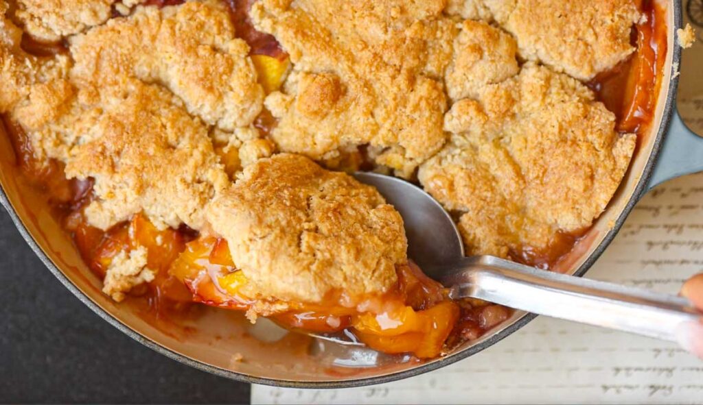 hero-shot-of-scooping-out-vegan peach-cobbler