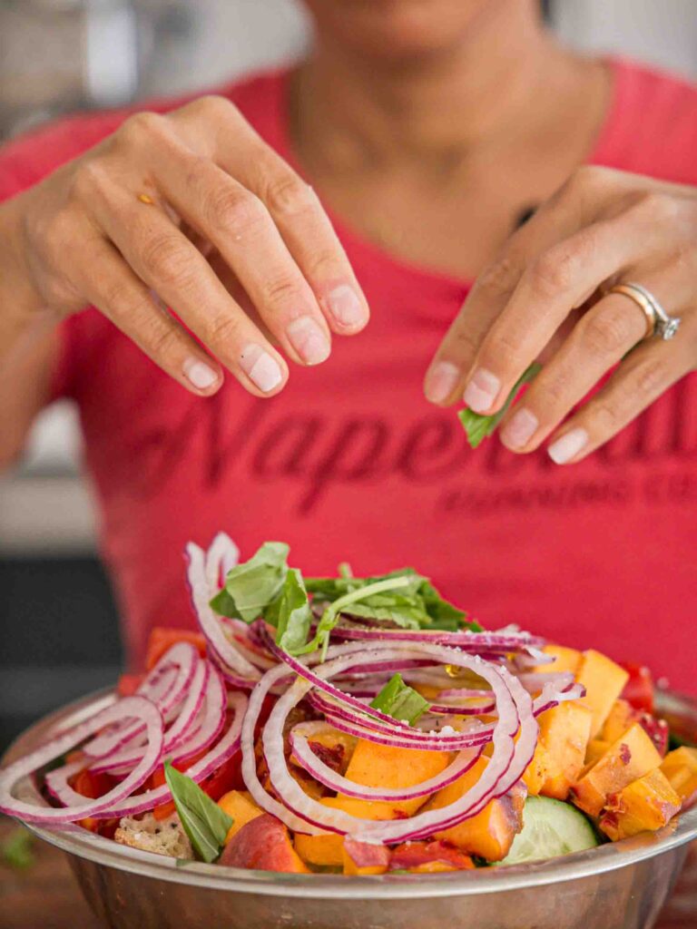 adding-basil-to-bread-salad