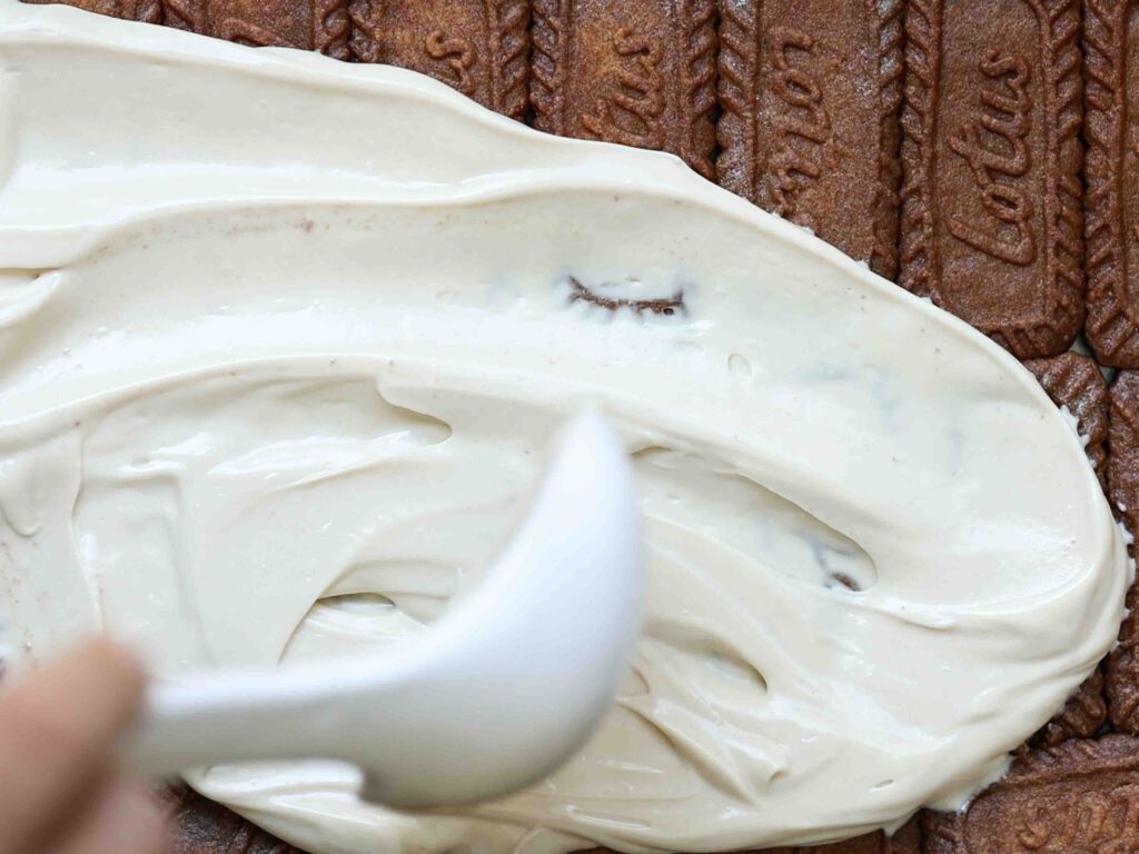 spreading-mascarpone-and-biscoff-buttercream-over-first-layer-of-cookies