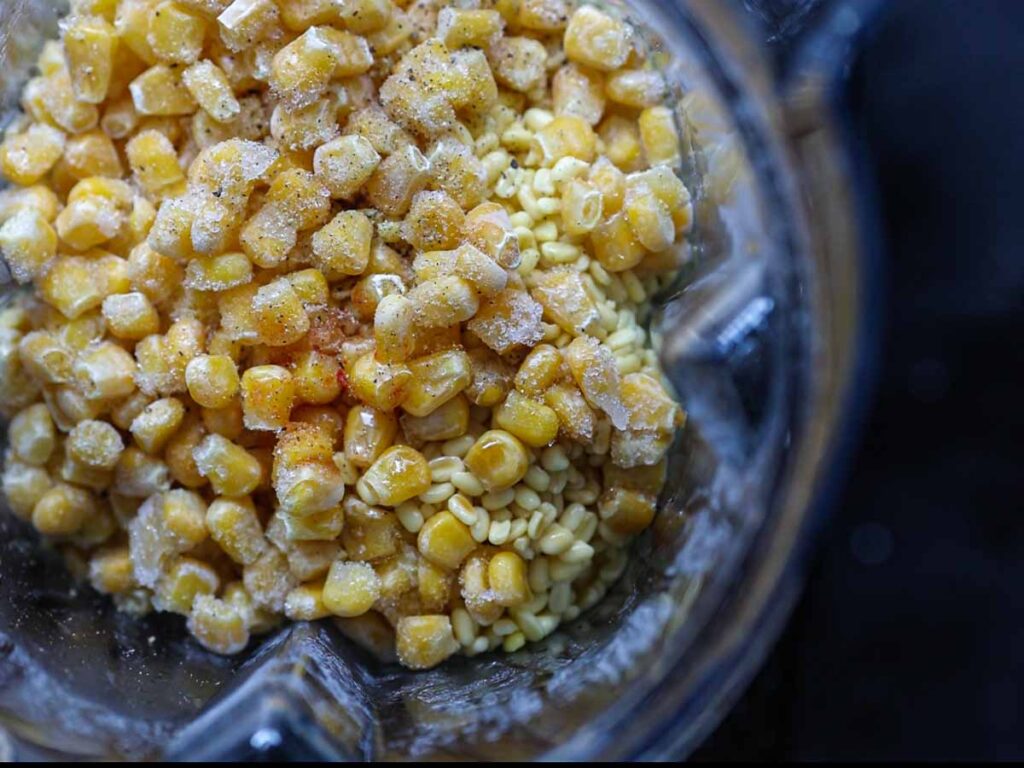 top-down-view-of-blender-containing-corn-mung-beans-soy-sauce-and-remaining-ingredients-for-batter