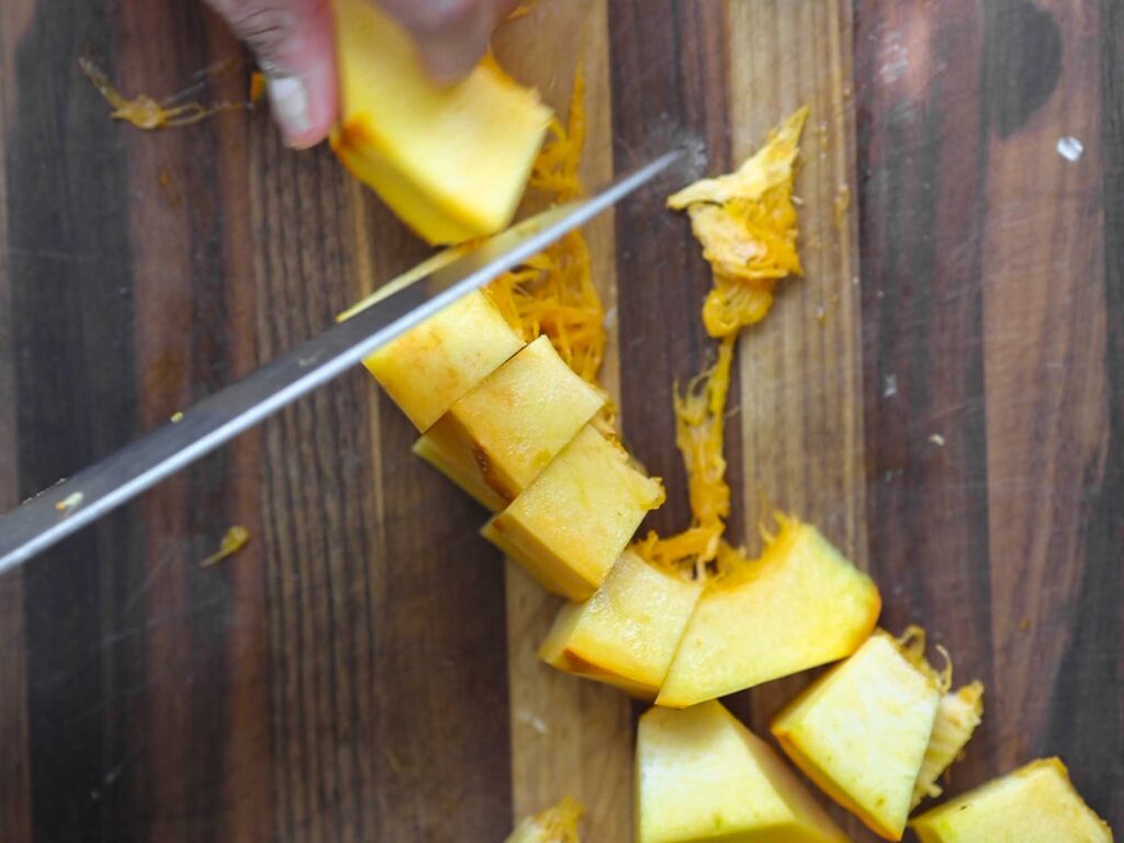 chopping up fresh pumpkin into cubes