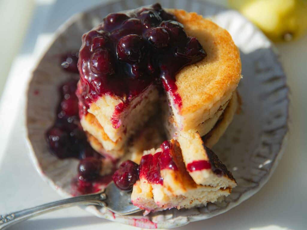 top down view of vegan lemon ricotta pancakes with blueberry sauce