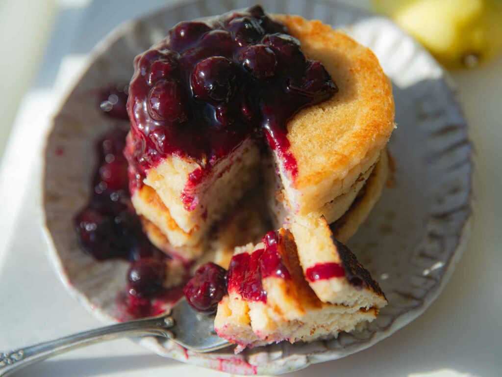 top down view of vegan lemon ricotta pancakes with blueberry sauce