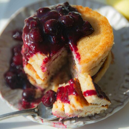 top down view of vegan lemon ricotta pancakes with blueberry sauce