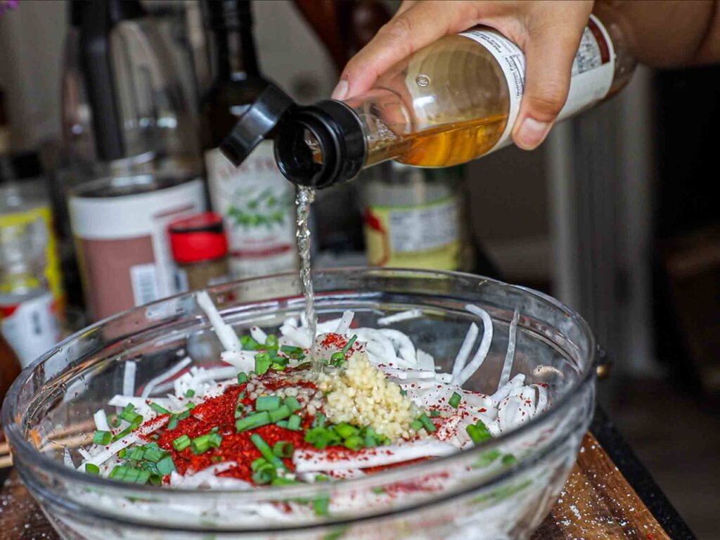 adding rice vinegar to julienned radish