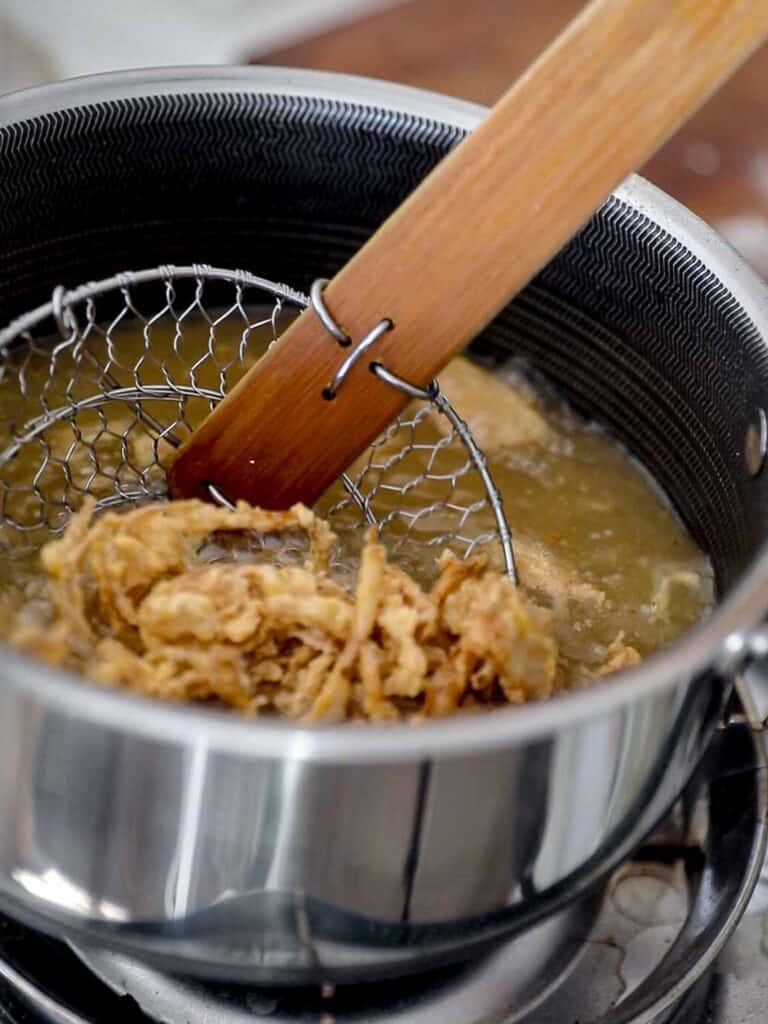 scooping out french fried shallots