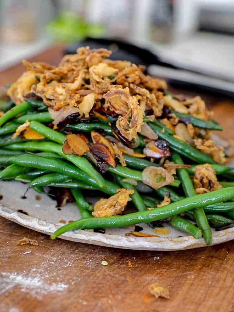 side view of green beans with French fried shallots