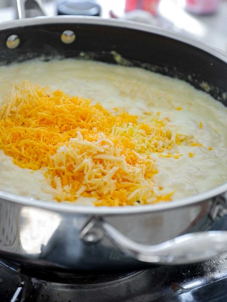 adding cheese to cream sauce