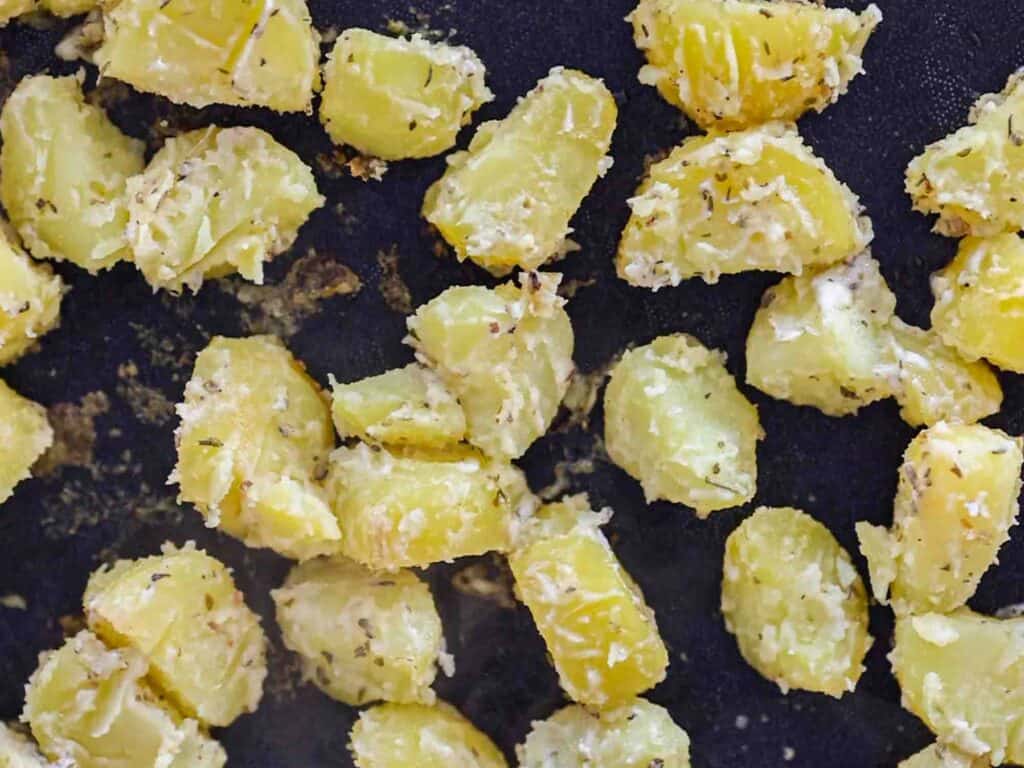 close up sheet pan of garlicky roasted potatoes before oven