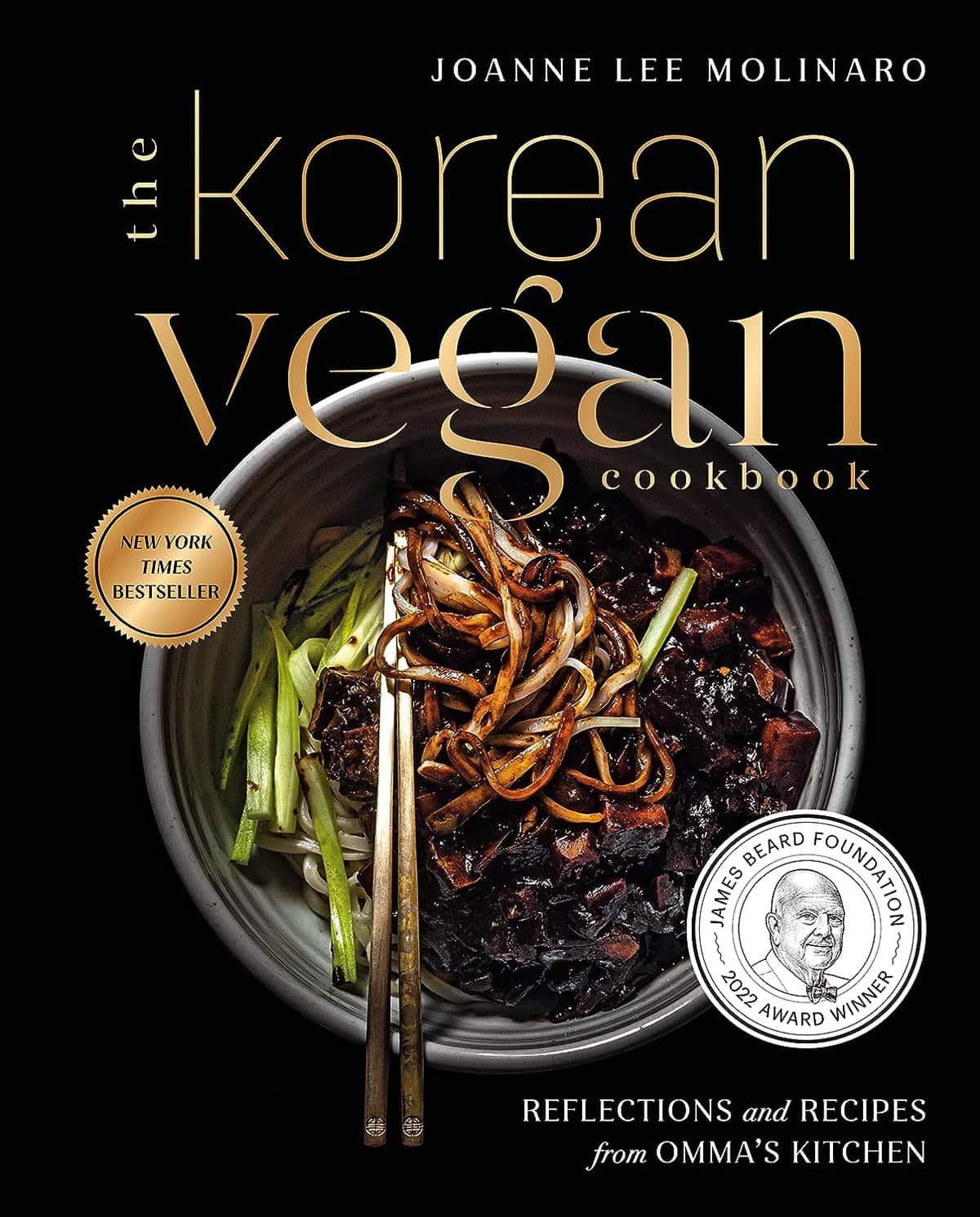 Cover of The Korean Vegan Cookbook by Joanne Lee Molinaro. This essential guide features a bowl of noodles with vegetables and chopsticks, perfect for a holiday gift. Includes text: New York Times Bestseller and James Beard Foundation 2022 Award Winner.