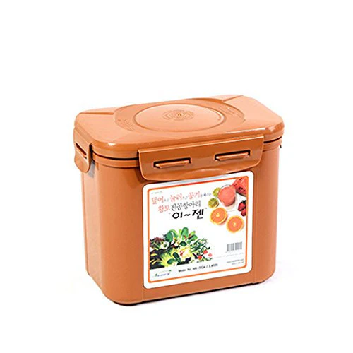 A tan kimchi container with a lid and handle features a label adorned with colorful fruits and vegetables.