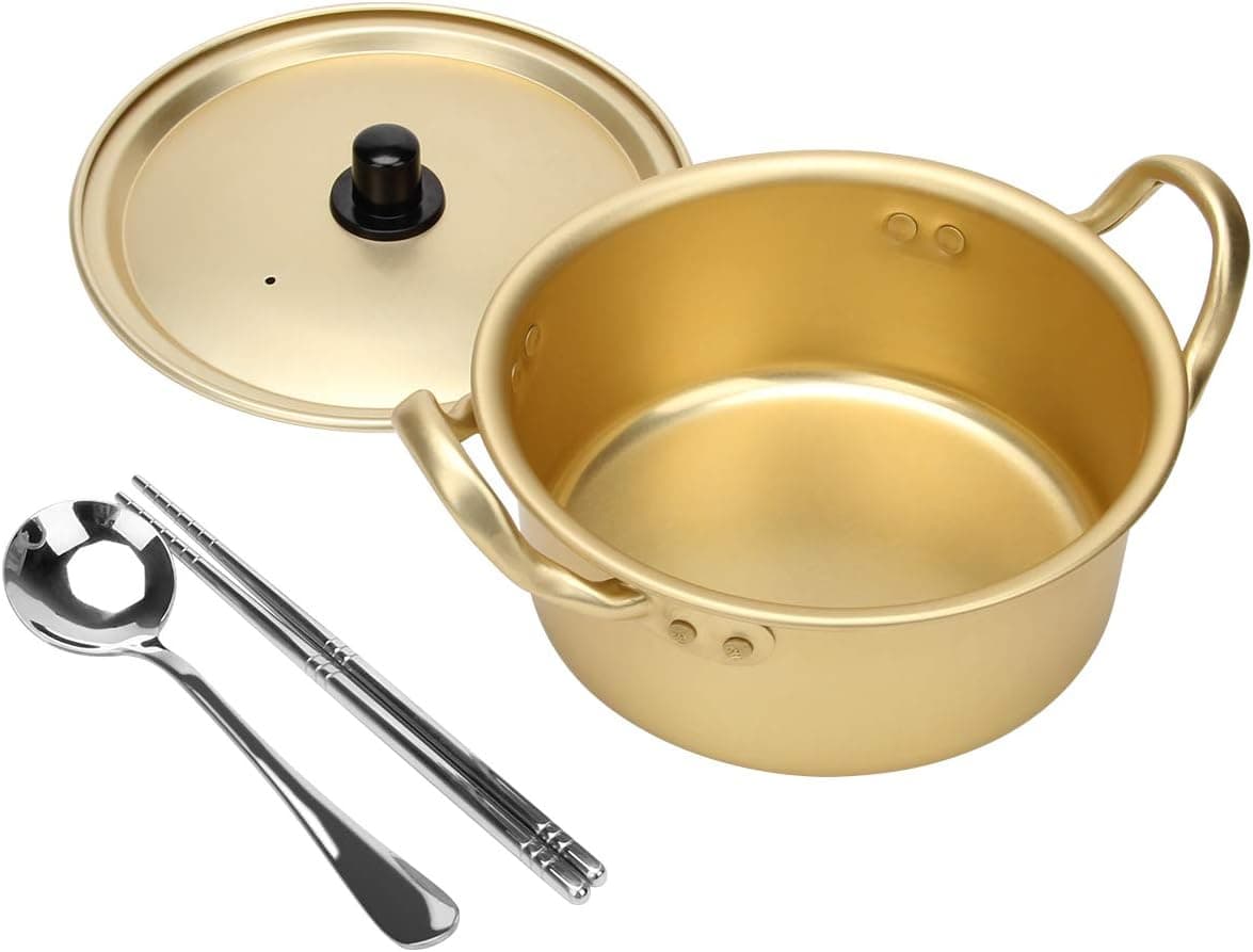 A golden pot with a matching lid is displayed alongside a silver spoon and a pair of chopsticks.  This elegant set features two handles and sleek, shiny utensils.