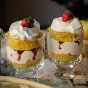 Delicious & Lemony Vegan Strawberry Shortcake Trifle. 48 Two vegan strawberry shortcake trifle glass cups filled with layered desserts: yellow sponge cake, whipped cream, and strawberries, topped with a dollop of cream and a whole strawberry on each.