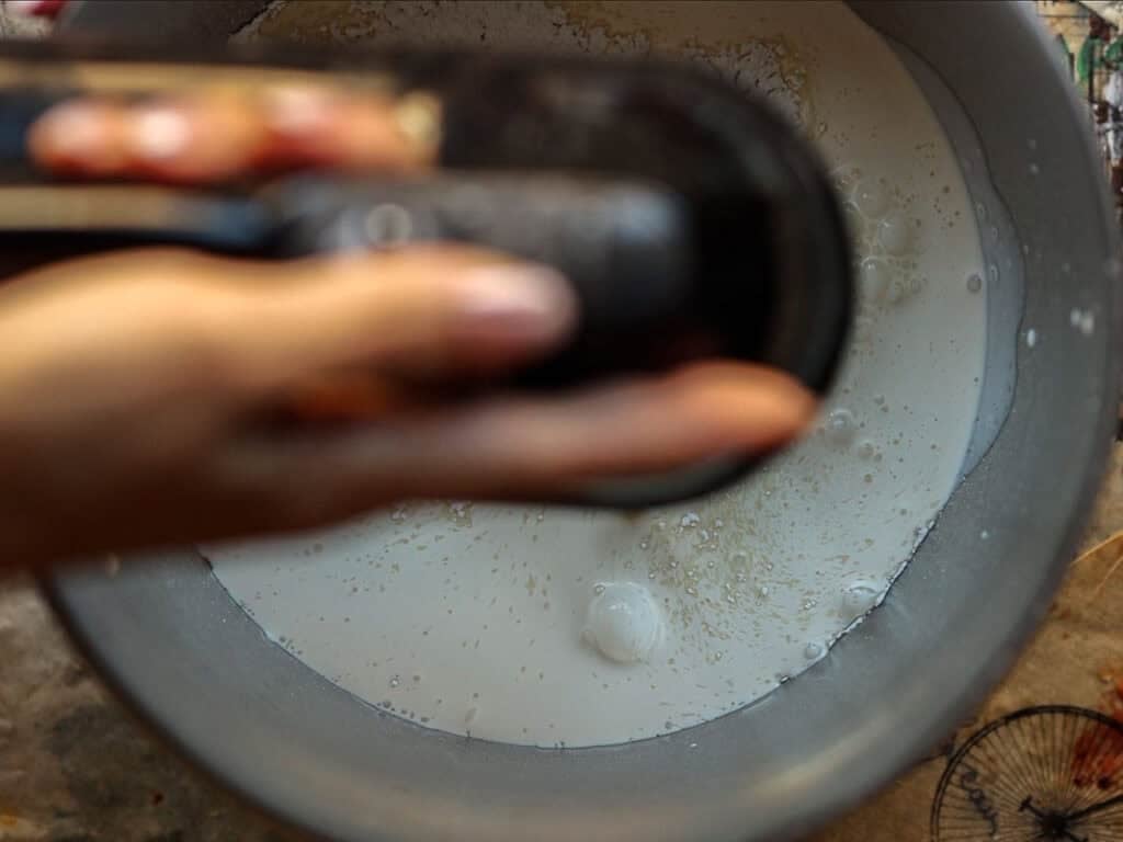 A person holding a mixer with a bowl of vegan heavy whipping cream.
