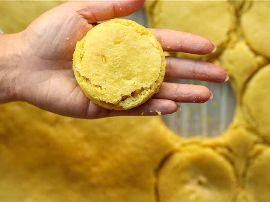holding round cut out of lemon cake for vegan strawberry shortcake trifle.