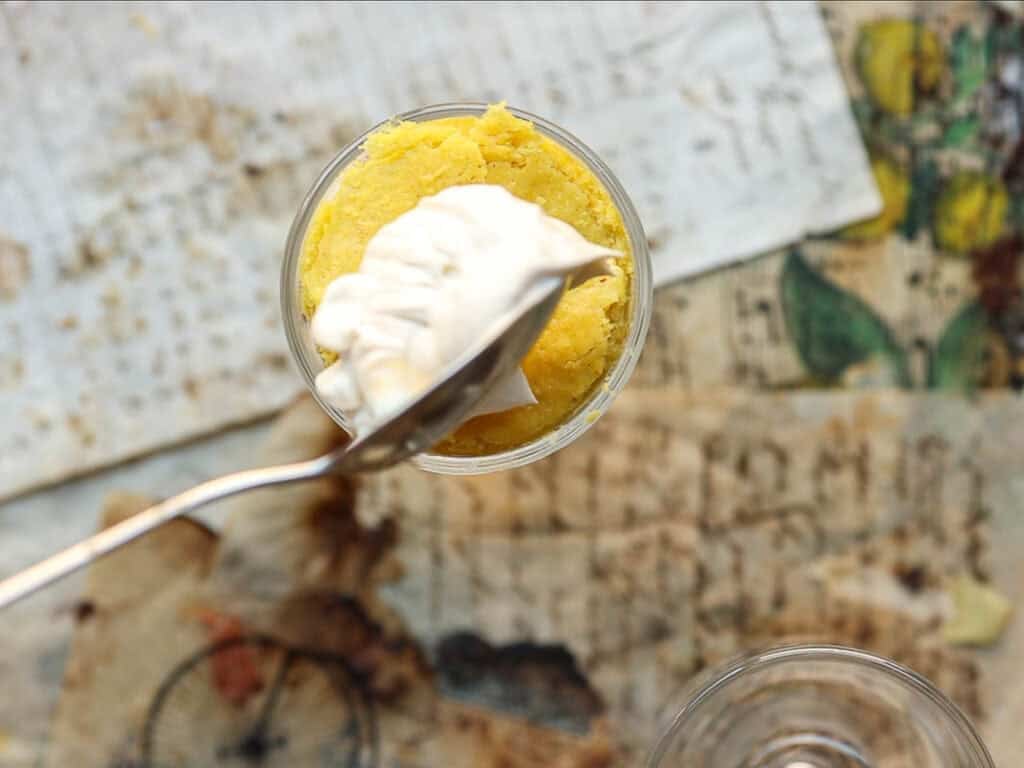 Adding whipped cream to top of trifle.