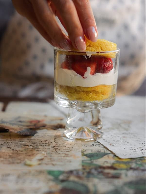 Adding top layer to vegan strawberry shortcake trifle.