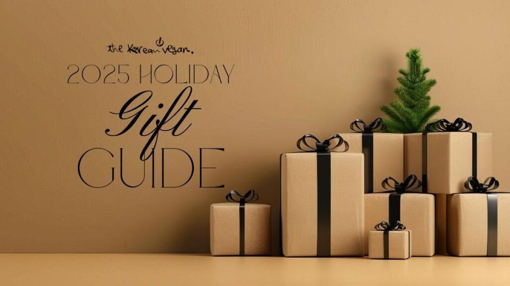 The Korean Vegan's 2025 VEGAN Holiday Gift GUIDE. 10 A minimalist holiday scene with beige gift boxes tied with black ribbons stacked beside a small green fir tree. Text reads “The Korean Vegan 2025 Holiday Gift Guide.”