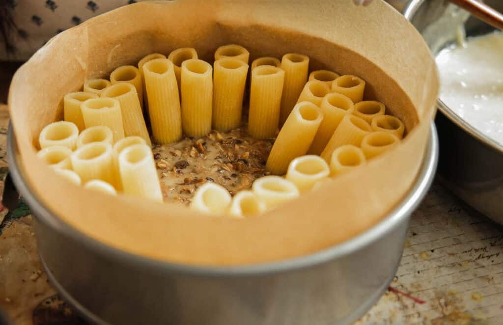 springform pan filled with creamy mushroom mixture and upright rigatoni.