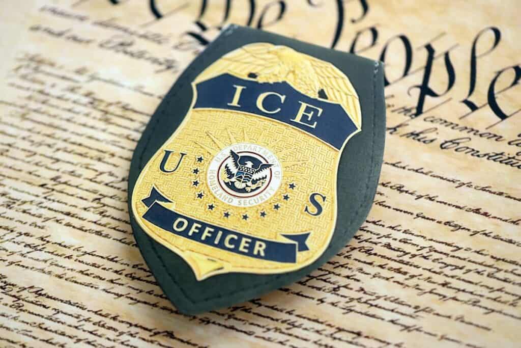 Law Q&A: ICE, Renee Good, and More. 12 A U.S. ICE officer badge rests on a copy of the U.S. Constitution, with "We the People" visible in the background—a powerful image featured in Renee Good’s Law Q&A series.