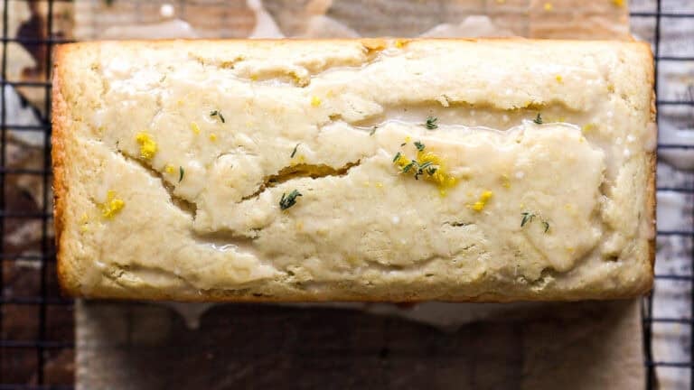 A vegan lemon loaf infused with fresh thyme, creating a fragrant and flavorful bread.