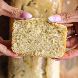 Easy Vegan Lemon Loaf Recipe - Better Than Starbucks 28 A person holding a freshly baked vegan lemon loaf.