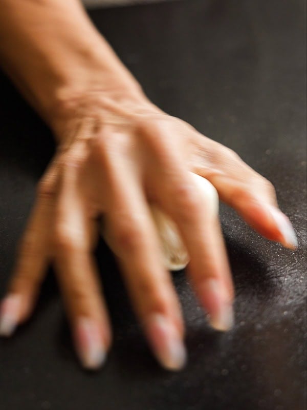 How to Make Viral Salt Bread Recipe (Easy and Vegan). 18 A close-up of a hand pressing down on a dough ball on a dark surface, about to crush it—perfect for adding bold flavor to your next viral recipe or homemade vegan bread.