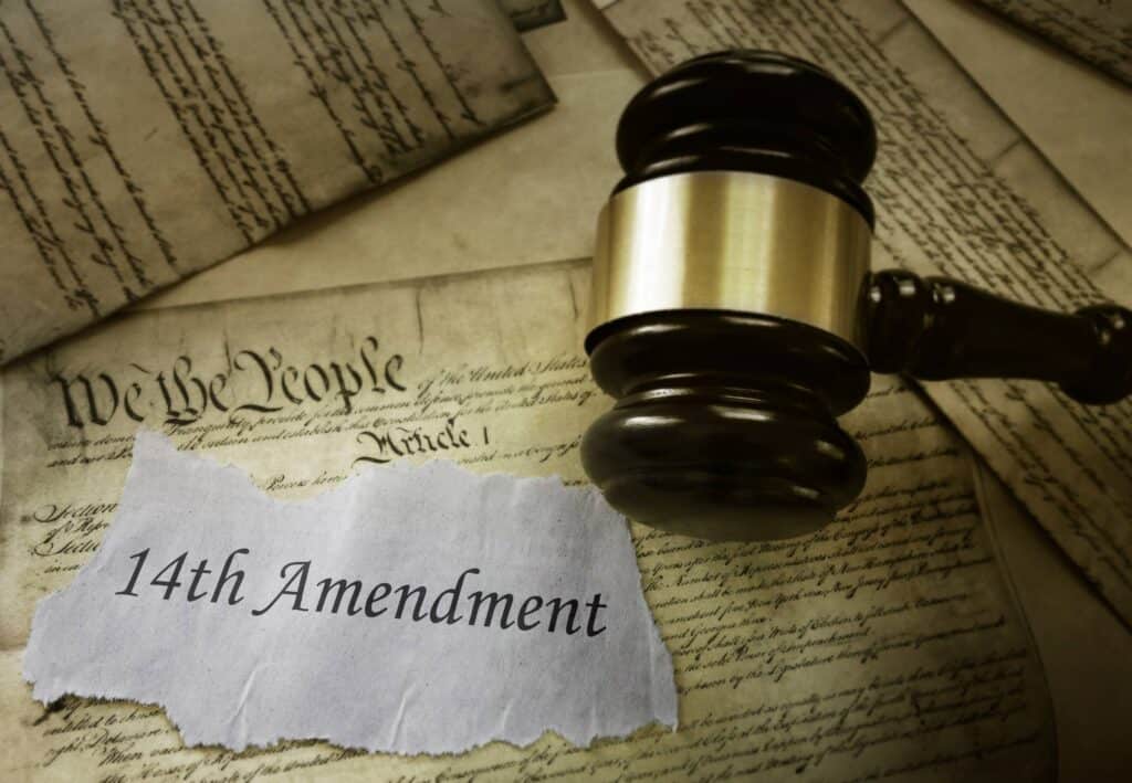A Short Primer on Birthright Citizenship. 11 A judge’s gavel rests on old documents, including part of the U.S. Constitution. A torn piece of paper in the foreground reads 14th Amendment, symbolizing a primer on birthright citizenship.